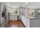 Modern kitchen featuring white cabinets, stainless steel appliances, light countertops, and wood flooring, offering style and functionality at 5170 Deephaven Ct, Denver, CO 80239