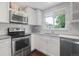 The kitchen has stainless steel appliances, white cabinets, and subway tile back splash, and a double basin sink at 5170 Deephaven Ct, Denver, CO 80239