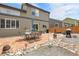 Spacious backyard featuring a stone patio with dining set, mature trees, and wood fence at 10540 Tracewood Cir, Highlands Ranch, CO 80130