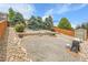 Large backyard with gravel and stone landscaping, mature trees, and fencing at 10540 Tracewood Cir, Highlands Ranch, CO 80130