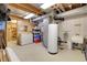 Unfinished basement with a water heater, storage shelves, and laundry sink at 4901 W 103Rd Cir, Westminster, CO 80031