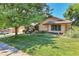 Charming single-story home with lush green lawn, mature tree, and classic architectural details at 4901 W 103Rd Cir, Westminster, CO 80031