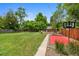 Large backyard featuring lush grass, mature trees, firepit, and basketball court at 6283 S Prescott St, Littleton, CO 80120