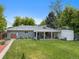 Expansive backyard with lush lawn, covered patio, and mature trees, perfect for outdoor enjoyment at 6283 S Prescott St, Littleton, CO 80120