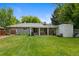 Spacious backyard featuring a covered patio with seating, storage shed, and a well-maintained lawn at 6283 S Prescott St, Littleton, CO 80120