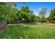 Expansive backyard featuring well-maintained lawn space with scattered trees and an outdoor seating area at 6283 S Prescott St, Littleton, CO 80120