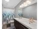 Spacious bathroom with a double sink vanity, a shower with decorative curtain, and ample lighting at 6283 S Prescott St, Littleton, CO 80120