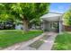 Single-story home featuring a mature shade tree and covered carport at 6283 S Prescott St, Littleton, CO 80120