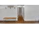 Inviting hallway with hardwood floors, coat hooks, bench, and neutral paint at 6283 S Prescott St, Littleton, CO 80120