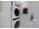 Convenient laundry room featuring a stacked washer and dryer with white cabinets at 6283 S Prescott St, Littleton, CO 80120