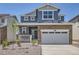 Charming two-story home featuring blue siding, stone accents, and a two-car garage at 683 N Deer Park St, Watkins, CO 80137