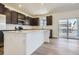 Modern kitchen with stainless steel appliances, island, and dark cabinets at 683 N Deer Park St, Watkins, CO 80137