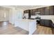 Modern kitchen with stainless steel appliances, island, and dark cabinets at 683 N Deer Park St, Watkins, CO 80137