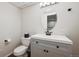 Modern bathroom featuring a white vanity, oval mirror, and neutral color scheme at 1623 E 164Th Pl, Brighton, CO 80602