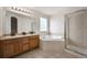 Well-lit bathroom with double vanity, corner tub, glass-enclosed shower, and ceramic tile floors at 1623 E 164Th Pl, Brighton, CO 80602