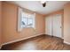 Bedroom with wood floors features closet with sliding doors and a view to the outside at 1623 E 164Th Pl, Brighton, CO 80602