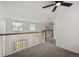 Bright hallway featuring a wooden staircase, neutral carpeting, and natural light from two windows at 1623 E 164Th Pl, Brighton, CO 80602