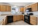 Kitchen with wood cabinets, black appliances, tile floor, and a view of neighborhood at 1623 E 164Th Pl, Brighton, CO 80602