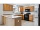 Bright kitchen features light wood cabinets and black appliances at 1623 E 164Th Pl, Brighton, CO 80602