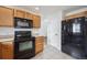 Kitchen features light wood cabinets and black appliances at 1623 E 164Th Pl, Brighton, CO 80602