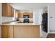 Kitchen features light wood cabinets, black appliances, and tile floors at 1623 E 164Th Pl, Brighton, CO 80602