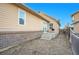 Backyard patio with steps leading down to a mulch ground cover area, next to another townhouse at 23317 E Saratoga Cir, Aurora, CO 80016