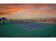 Well-maintained blue and green tennis court with a view of neighborhood and colorful sunset at 23317 E Saratoga Cir, Aurora, CO 80016