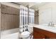 Well-lit bathroom with tiled walls, a shower/tub, and a modern vanity at 4334 Lisbon St, Denver, CO 80249