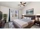 A large primary bedroom with a comfortable queen-sized bed, a ceiling fan, and an art piece at 4334 Lisbon St, Denver, CO 80249