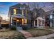 Evening view of a two-story home showcasing exterior lighting, landscaping, and a welcoming front porch at 713 S Washington St, Denver, CO 80209