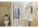 Cozy bathroom with a white pedestal sink, decorative shower curtain, and hexagon mirror at 14231 E Dickinson Dr # E, Aurora, CO 80014