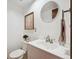 Well-lit half bathroom with a vanity sink, round mirror, and modern decor at 14231 E Dickinson Dr # E, Aurora, CO 80014