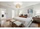 Bright bedroom featuring wood floors, neutral colors, woven light fixture, and ensuite bathroom access at 536 N Williams St, Denver, CO 80218