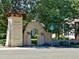 Street view of an arched entrance to a neighborhood, with stone pillars and lush greenery at 536 N Williams St, Denver, CO 80218