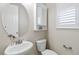 Charming half bathroom with a pedestal sink, round mirror, and shuttered window at 3323 Starry Night Loop, Castle Rock, CO 80109