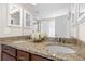 Elegant bathroom featuring dual sinks, granite countertops, and wood cabinets at 3323 Starry Night Loop, Castle Rock, CO 80109