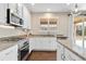 A modern kitchen with white cabinets, stainless steel appliances, granite countertops, and hardwood floors at 3323 Starry Night Loop, Castle Rock, CO 80109