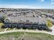 An elevated view of a neighborhood showcasing a row of modern townhouses with well-kept lawns and sidewalks at 22725 E Ottawa Pl, Aurora, CO 80016