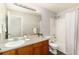 Bright bathroom with shower-tub combo, wood vanity and large mirror at 22725 E Ottawa Pl, Aurora, CO 80016