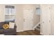 Bright foyer with wood floors, a white front door, and a staircase leading upstairs near a cozy couch at 22725 E Ottawa Pl, Aurora, CO 80016