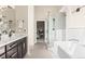 Bright bathroom with a modern vanity, large frameless shower, and a separate soaking tub with tiled floors at 4 Greenridge Rd, Greenwood Village, CO 80111