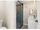 Bathroom featuring a frameless glass shower with dark tile, a white vanity, and modern fixtures at 4 Greenridge Rd, Greenwood Village, CO 80111