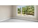 Empty bedroom with a large window offering tree views, neutral paint and carpet at 4 Greenridge Rd, Greenwood Village, CO 80111