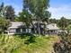 A full exterior aerial shot of the home with mature trees and lush green lawn at 4 Greenridge Rd, Greenwood Village, CO 80111