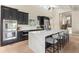 Modern kitchen boasts sleek black cabinets, stainless steel appliances, and a large waterfall island with seating at 4 Greenridge Rd, Greenwood Village, CO 80111