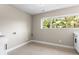 Bright laundry room with a window offering a view of the trees, and sleek white cabinets at 4 Greenridge Rd, Greenwood Village, CO 80111