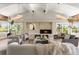 Open living room with vaulted ceilings, beams, stone fireplace, and lots of natural light at 4 Greenridge Rd, Greenwood Village, CO 80111