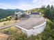 Aerial view of large modern home featuring a large driveway and mountain views at 18844 Ute Vista Trl, Morrison, CO 80465