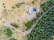 Aerial view of a modern mountain home with a driveway winding through lush trees and vegetation at 18844 Ute Vista Trl, Morrison, CO 80465