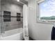 Bathroom featuring tiled walls, a bathtub, a window with a view, and modern fixtures for a luxurious bathing experience at 18844 Ute Vista Trl, Morrison, CO 80465